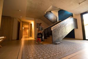 a woman walking down a hallway with a staircase at Can Alemany in Santa Margarita de Mombúy