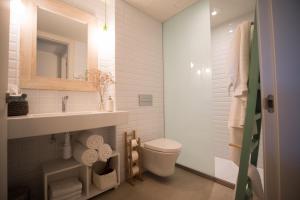 a bathroom with a toilet and a sink and a mirror at Can Alemany in Santa Margarita de Mombúy