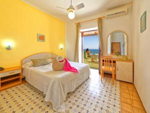 a bedroom with a bed and a table and a mirror at Hotel Villa Franz in Ischia