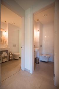 a bathroom with two toilets and a tub and a sink at Can Alemany in Santa Margarita de Mombúy