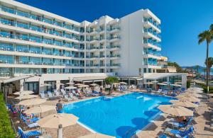 un hotel con una grande piscina con sedie e ombrelloni di Hipotels Hipocampo - Adults Only a Cala Millor