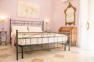 Schlafzimmer mit einem schwarzen Bett und einem Spiegel in der Unterkunft Casa Albigiò in Catania