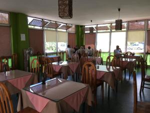 a restaurant with tables and chairs with people sitting at them at Motel d'Antananarivo in Antananarivo