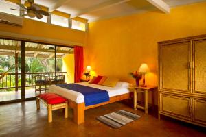 a bedroom with a bed in a room with yellow walls at Villas del Caribe in Puerto Viejo