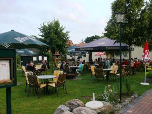a group of people sitting at tables and umbrellas at Landgasthof "Wirtshaus Zur Eibe" in Jabel