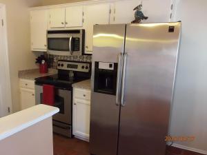 a kitchen with a stainless steel refrigerator and a microwave at Biloxi Charmer in Biloxi