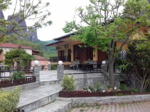 Guesthouse Papastathis في كالامباكا: منزل مع شرفة وفناء