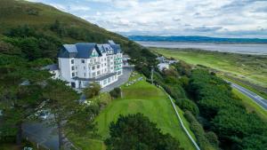 an aerial view of a building on a hill next to the water at Trefeddian Hotel in Aberdyfi