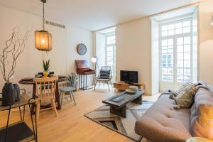 a living room with a couch and a table at Almaria - Officina Real Apartments | Chiado in Lisbon