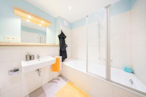 a bathroom with a tub and a sink and a shower at Design Apartments - "Potsdam West", 80 in Potsdam +10 photos