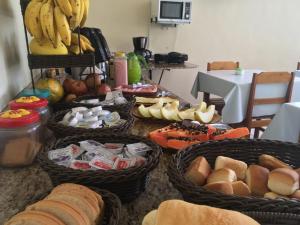 a table with baskets of bread and fruit on it at Hotel Comodoro De Bagé in Bagé