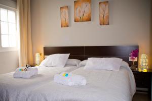 1 dormitorio con 2 camas y toallas. en Hostal La Muralla, en Sevilla