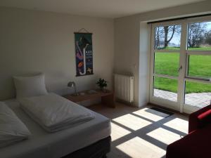 a bedroom with a bed and a large window at Søfryd B&B in Præstø