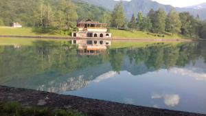 a reflection of a building in the water at Apartman Košuta 2 in Tjentište