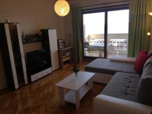 a living room with a couch and a tv and a table at Apartman Una in Crikvenica