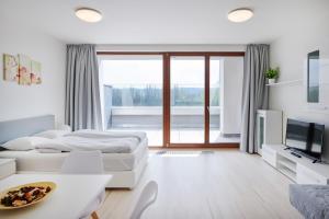 a white room with two beds and a television at Residence Nad Vltavou in Prague