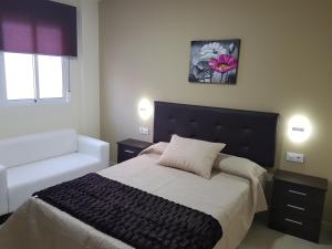 sypialnia z dużym łóżkiem z czarnym zagłówkiem w obiekcie Hostal Málaga w mieście Arcos de la Frontera