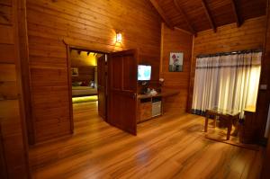 a living room with wooden walls and a wooden floor at LakeRose Wayanad Resort in Ambalavayal