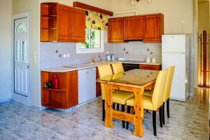 cocina con mesa de madera y sillas amarillas en Panochori Apartment, en Valsamáta