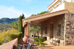eine Veranda eines Hauses mit Stühlen und einer Terrasse in der Unterkunft Villa Bella Portbou in Portbou