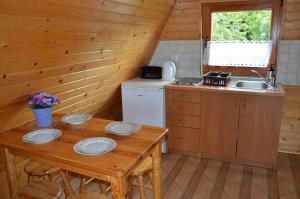a kitchen with a table and a sink in a cabin at 7 Dziewczyn in Dźwirzyno