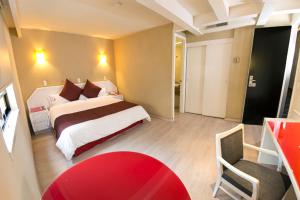 Habitación de hotel con cama y mesa roja en Hotel Regente, en Ciudad de México