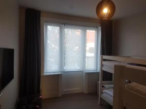 a bedroom with a large window and a bed at B&B Logies Charles Cabour in De Panne