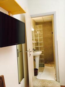 a bathroom with a tv on the wall and a sink at Boutique Hotel Couleurs Suds in Cannes +81 photos