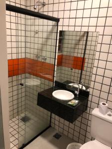 La salle de bains est pourvue d'un lavabo et d'un miroir. dans l'établissement Hotel Romance (Adults Only), à São Paulo