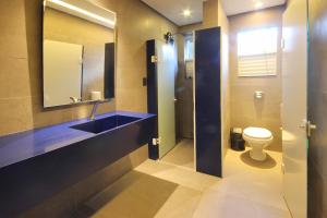 a bathroom with a toilet and a sink and a mirror at Cris Hotel in Florianópolis