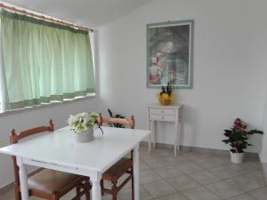 a white table and chairs in a room with a window at Strada dei Frutteti in Tavullia