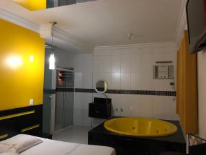 Habitación con baño con bañera amarilla. en Hotel Romance (Adults Only) en São Paulo