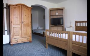 a bedroom with two beds and a tv and a crib at Appartementhaus Huber in Abersee 