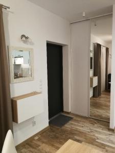 łazienka z umywalką i lustrem na ścianie w obiekcie Domek przy lesie w Gdańsku