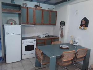 a kitchen with a table and a white refrigerator at Calm Point Home in Volissos