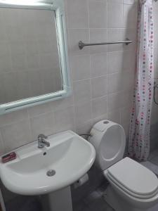 a bathroom with a sink and a toilet and a mirror at Calm Point Home in Volissos +24 photos