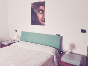 a bedroom with a bed and a painting on the wall at Strada dei Frutteti in Tavullia