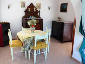 une table et des chaises avec un vase de fleurs. dans l'établissement Manderley-Case sul mare, à Santa Caterina