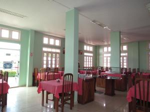 un restaurante con mesas y sillas rosas y ventanas en Hotel Mirante Da Ilha, en Alter do Chao