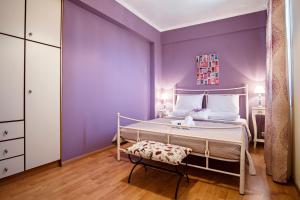 a purple bedroom with a bed and a chair at Birdsing Cottage in Dassia