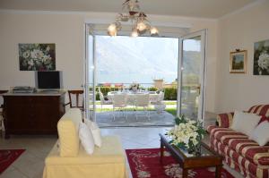 Casa Eleganza في تريميزو: غرفة معيشة مع أريكة وغرفة طعام