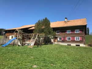 une maison avec une aire de jeux en face d'une maison dans l'établissement Bergstätt Lodge, à Immenstadt