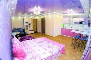 a living room with a bed and a kitchen at ApartLux on Slavskogo 26 View River in Ustʼ-Kamenogorsk