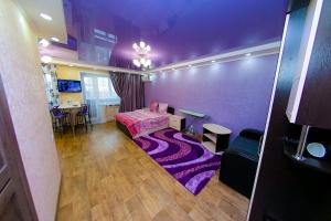 Cette chambre violette comprend un lit et un tapis. dans l'établissement ApartLux on Slavskogo 26 View River, à Öskemen