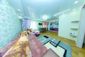 ein Schlafzimmer mit einem Bett und ein Zimmer mit einem Tisch in der Unterkunft ApartLux on Republic Square in Öskemen