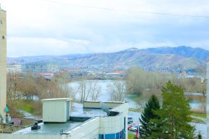 Blick auf eine Stadt mit Fluss und Berge in der Unterkunft ApartLux on Republic Square in Öskemen