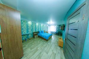 a bedroom with a bed in a room with blue walls at Apart Auezov street City Centr in Ustʼ-Kamenogorsk