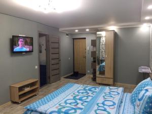 a bedroom with a bed and a tv on the wall at Apart Auezov street City Centr in Ustʼ-Kamenogorsk