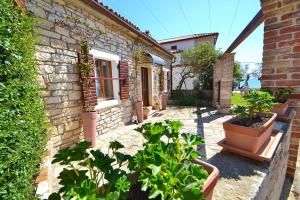 een bakstenen huis met potplanten ervoor bij Villa Giardin in Novigrad Istria