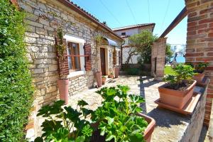 una casa di mattoni con piante in vaso di fronte di Villa Giardin a Novigrad Istria